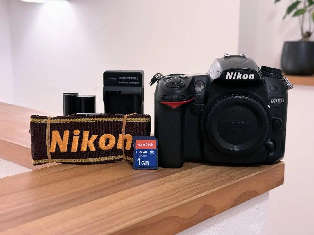 Nikon D7000 y batería original, cargador, tarjeta SD, correa incluida