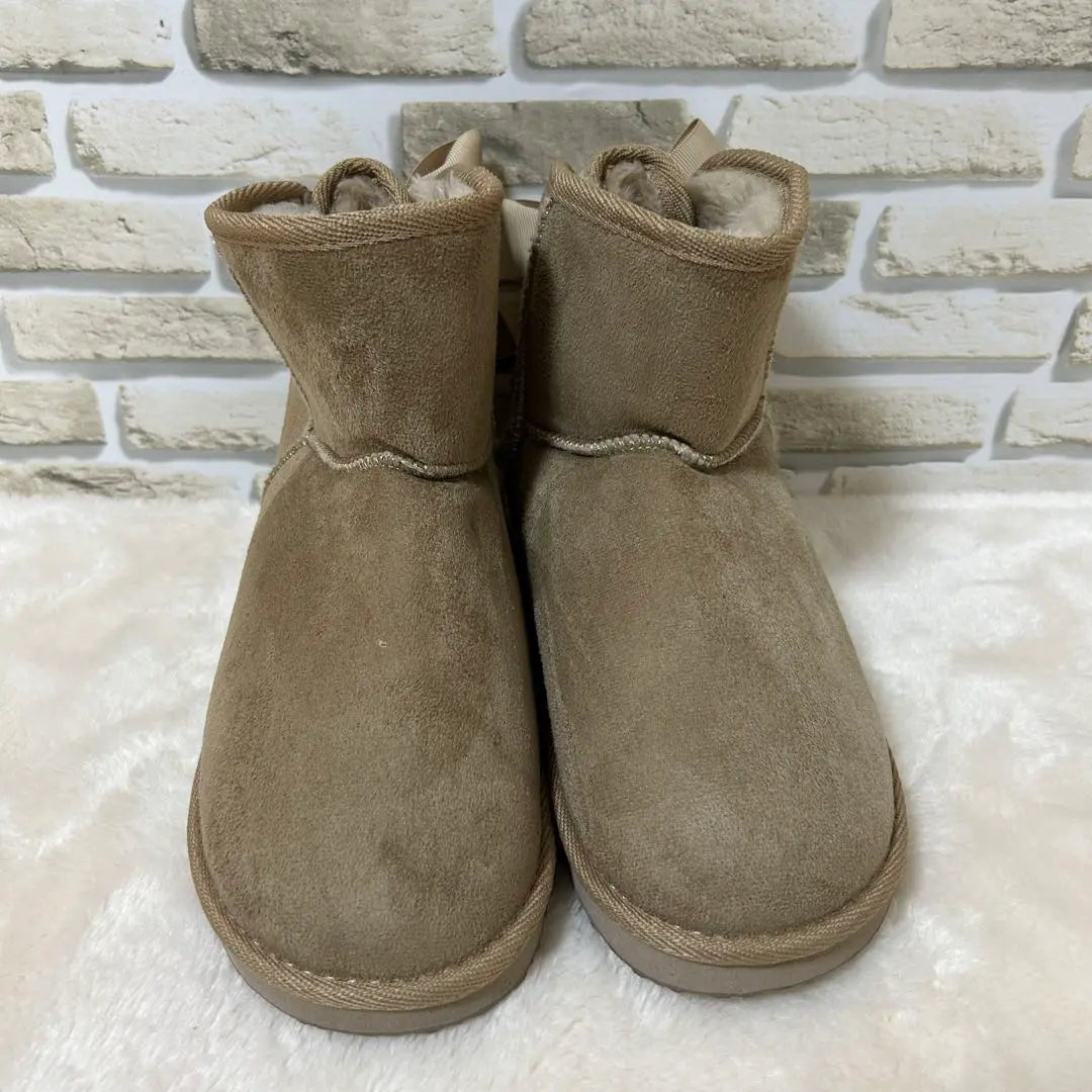 Bonitas botas de gamuza color beige con lazo en la parte posterior