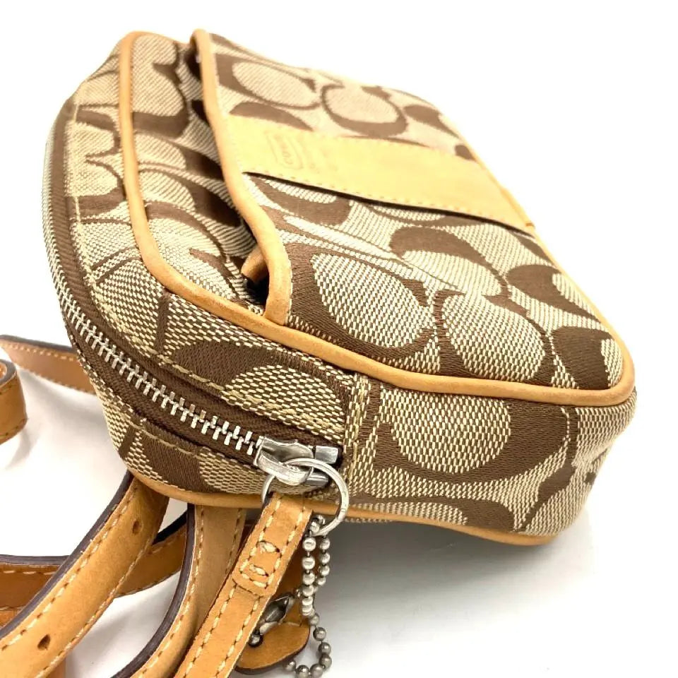 Riñonera de cuero beige con la firma de COACH