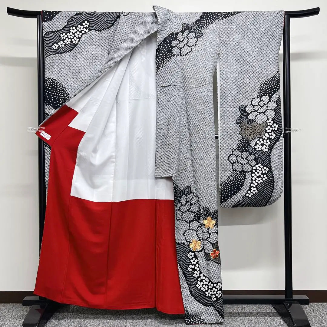 Un kimono monocromático con un kimono de manga larga con piezas doradas bordadas en toda la corbata.